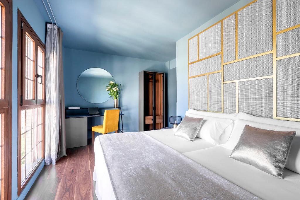 潘普洛纳潘普洛纳大教堂酒店的卧室配有一张白色大床和一张书桌