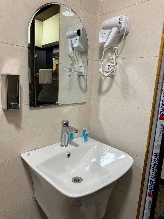 巴格达SAFIR BAGHDAD HoTEL的浴室盥洗盆配有镜子和吹风机