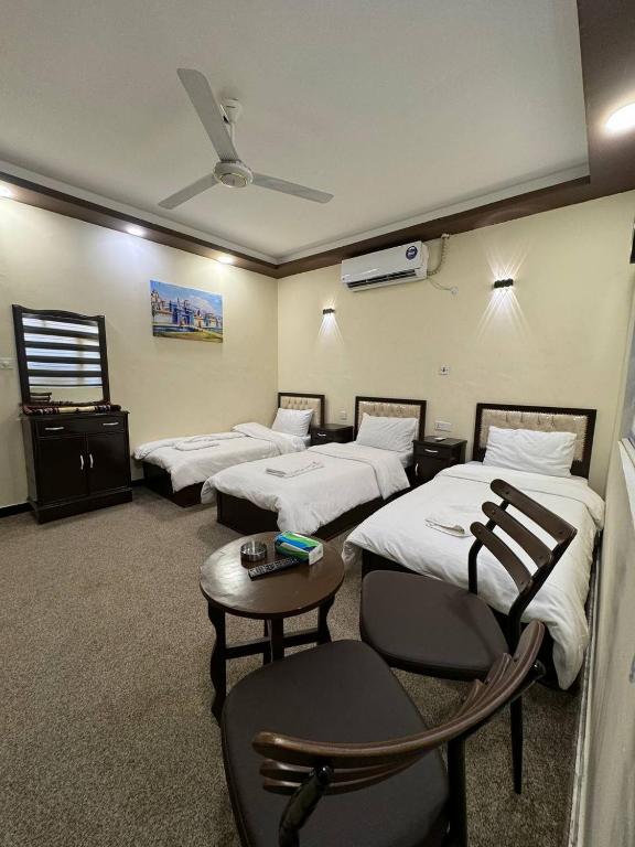 巴格达SAFIR BAGHDAD HoTEL的酒店客房设有三张床和一张桌子