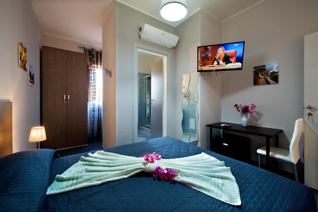 巴蒂帕利亚B&B Suite 123的一间卧室配有一张带鲜花的蓝色床