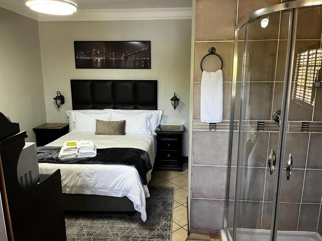 比勒陀利亚Klyne Jiweel Guesthouse的一间卧室配有一张床和淋浴