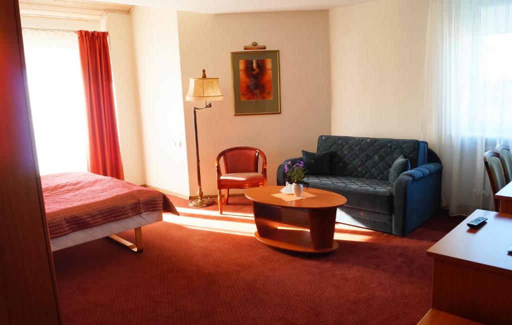 克雷廷加Motelis Smagratis Kretinga的酒店客房,配有床和沙发