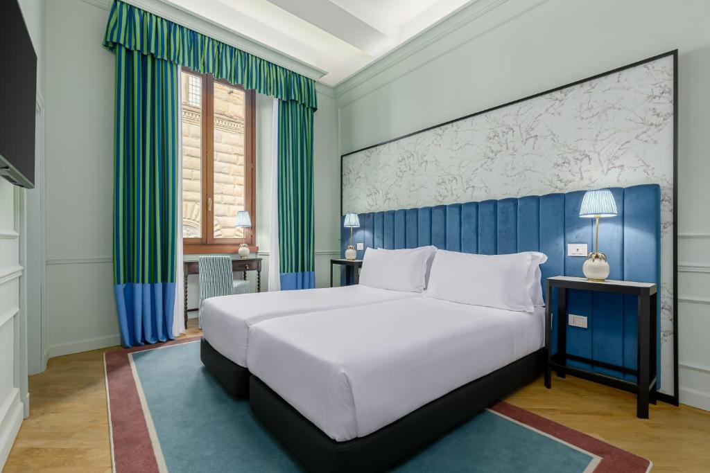 佛罗伦萨伊莎贝拉室友酒店的卧室配有白色大床和绿色窗帘