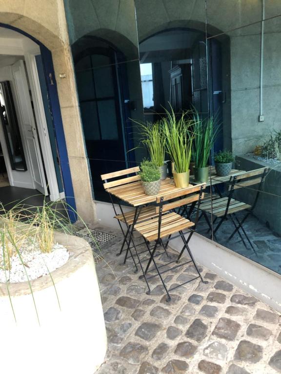 里尔Au cœur du VIEUX-LILLE : Charmant appartement的天井上摆放着桌椅和盆栽植物