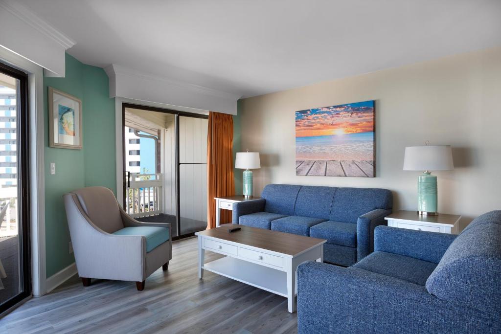 默特尔比奇默特尔海滩加勒比度假酒店的客厅配有蓝色的沙发和椅子