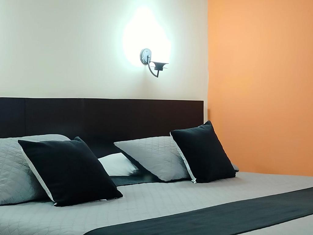 波帕扬Hotel La Herreria Colonial的一间卧室配有一张带黑白枕头的床