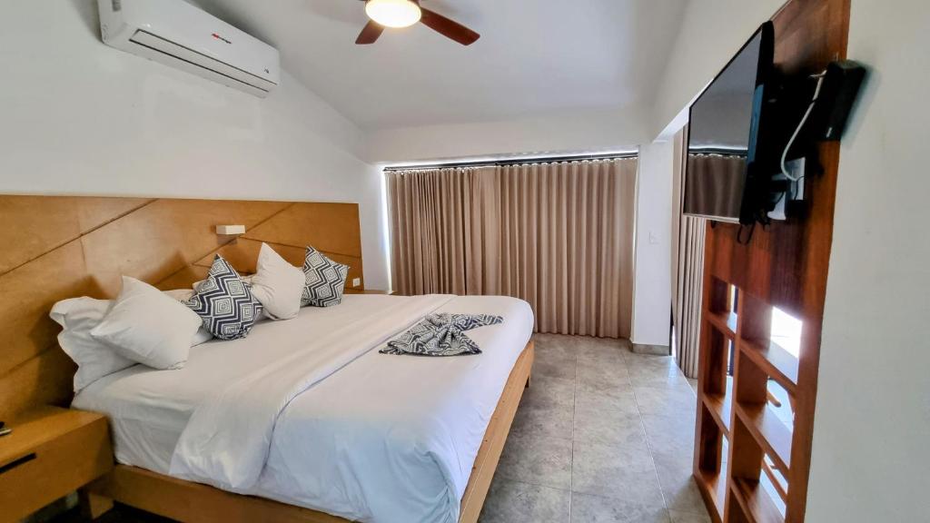 雪松山Buena Vista Oceanfront & Hot Springs Resort的一间卧室配有一张床和一台平面电视