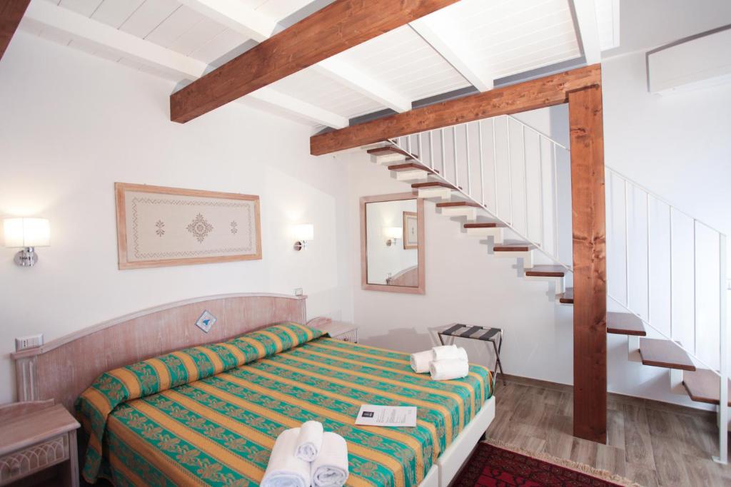 托尔托利Locanda degli Artisti的一间卧室设有一张床和一个楼梯