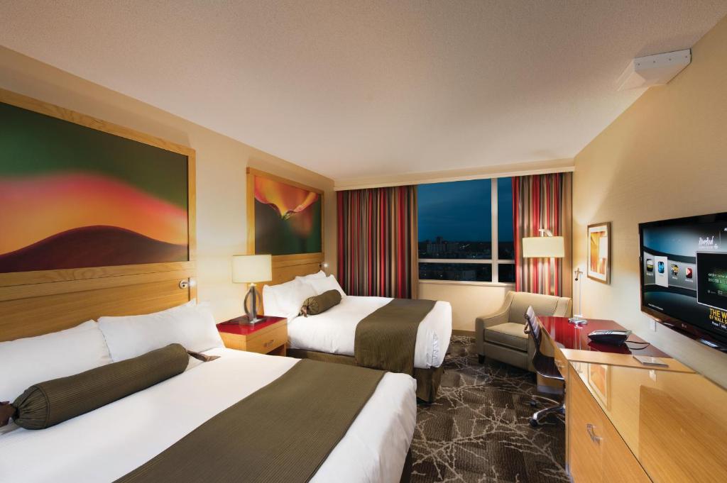 里士满River Rock Casino Hotel的酒店客房设有两张床和一台平面电视。