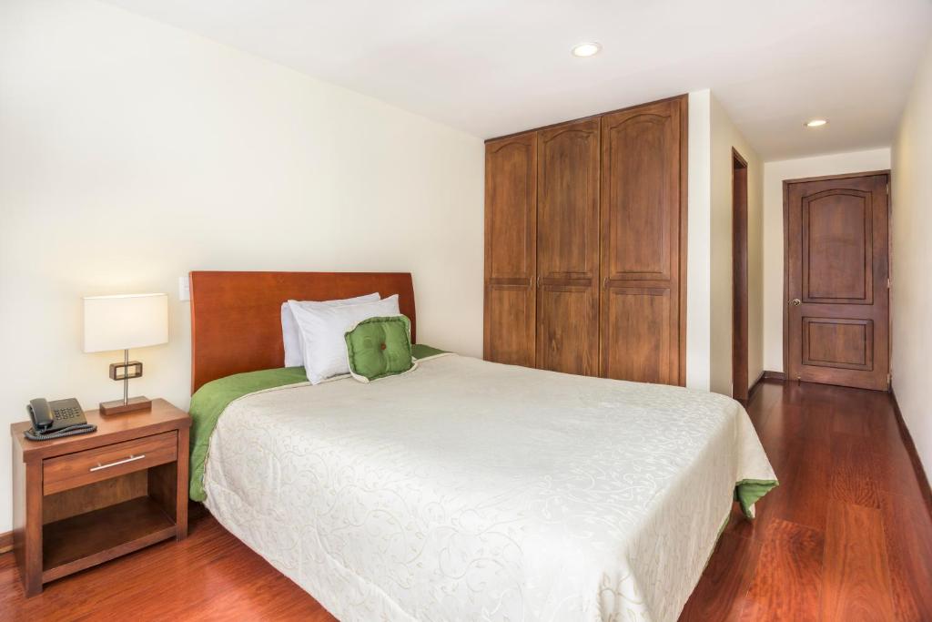 波哥大波托菲诺住宿加早餐旅馆的一间卧室配有一张大床和一个木制橱柜