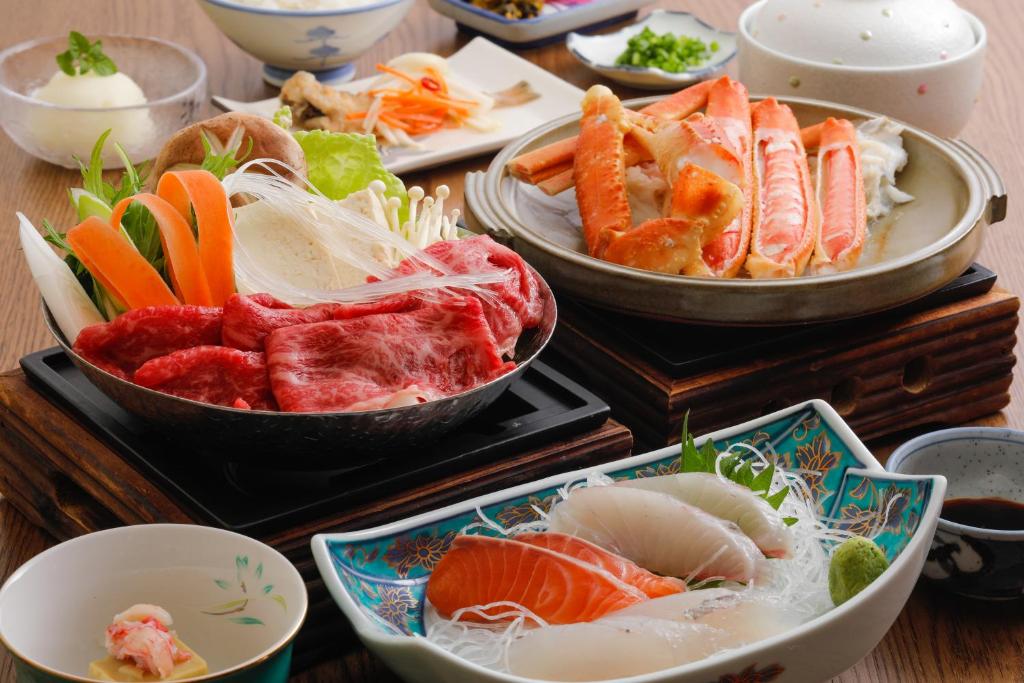 丰冈市Tsuruya Ryokan的桌子上放着各种食物的碗