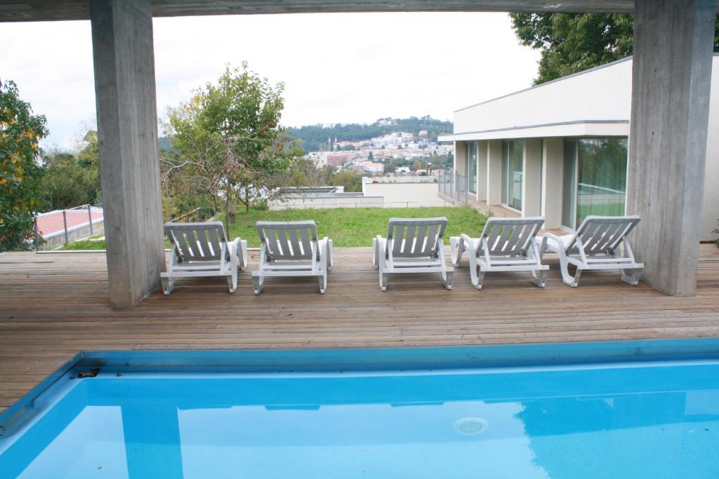 布拉加卡斯坦内罗度假屋的游泳池旁甲板上四把躺椅