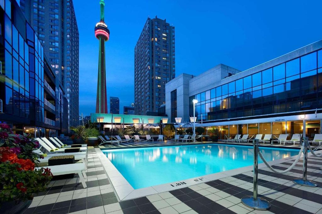 多伦多Radisson Blu Toronto Downtown的一座城市的游泳池,塔楼在后面