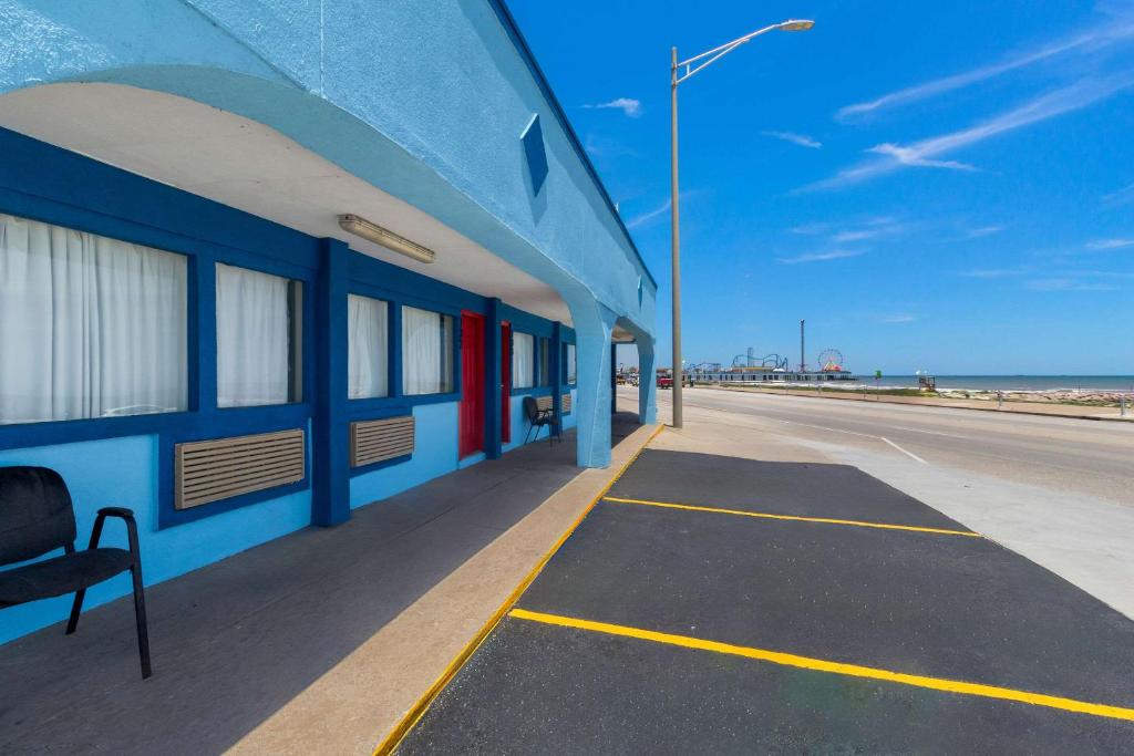加尔维斯敦Econo Lodge Galveston Seawall的海滩边的蓝色建筑
