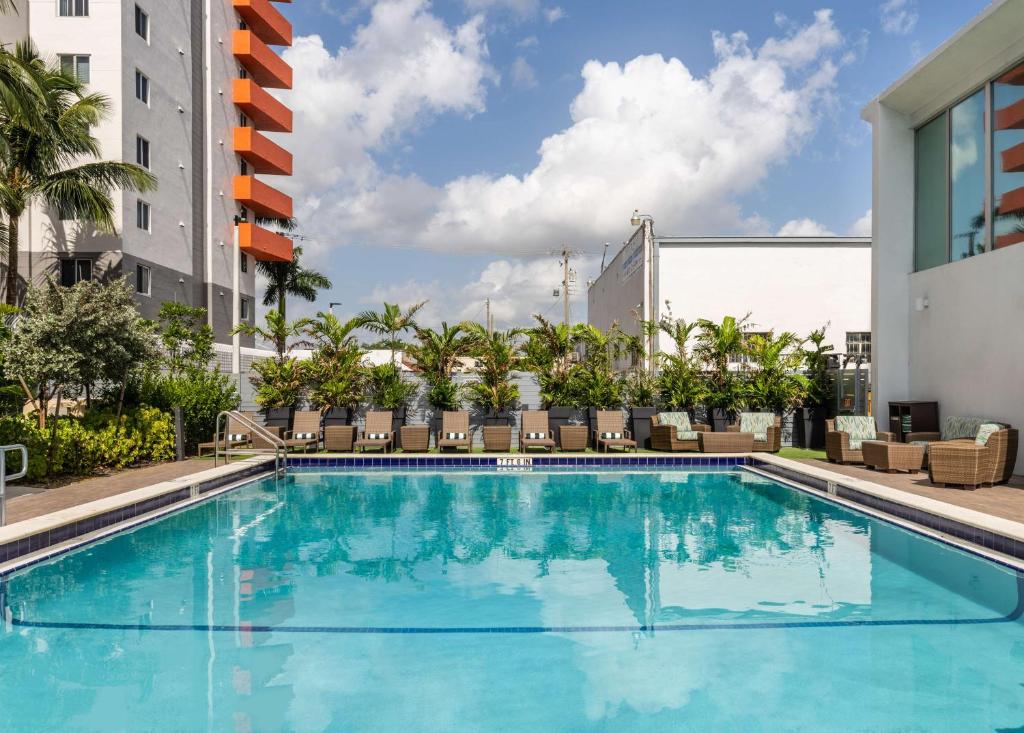 迈阿密DoubleTree by Hilton Miami North I-95的一座带椅子的游泳池以及一座建筑