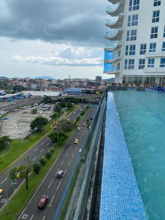 巴拿马城Apartamento en Avenida Balboa的享有道路和一座带游泳池的建筑的顶部景致