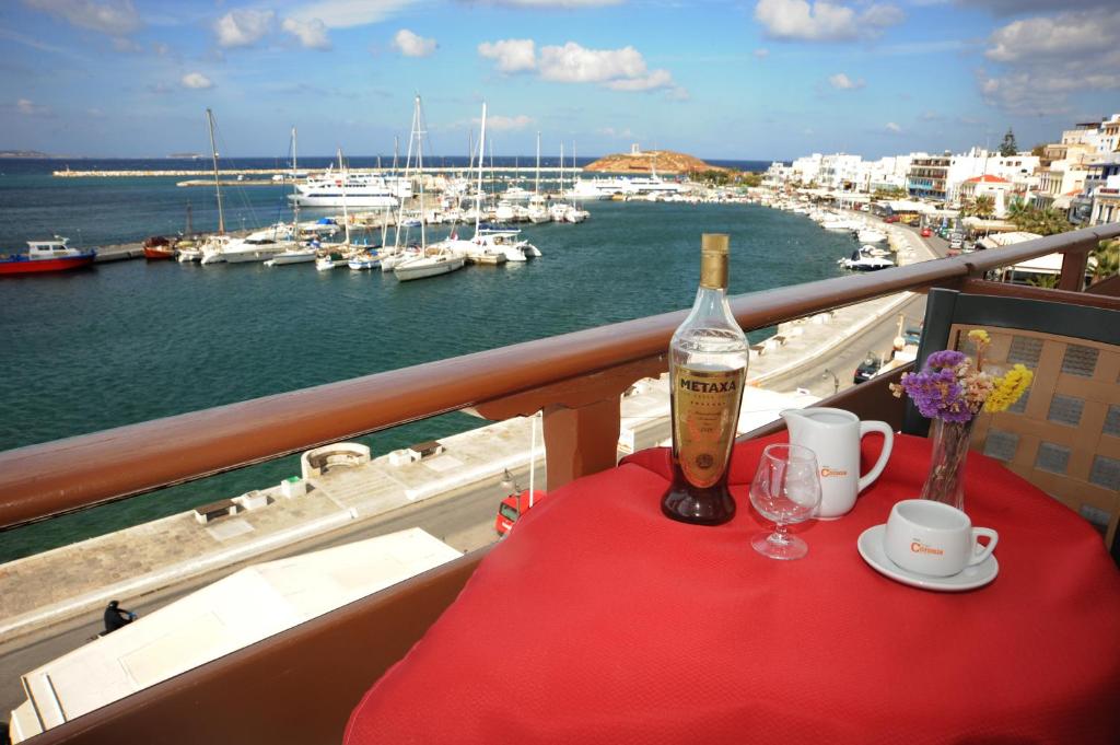 纳克索乔拉卡洛尼斯酒店的阳台上的桌子上摆放着一瓶葡萄酒和玻璃杯