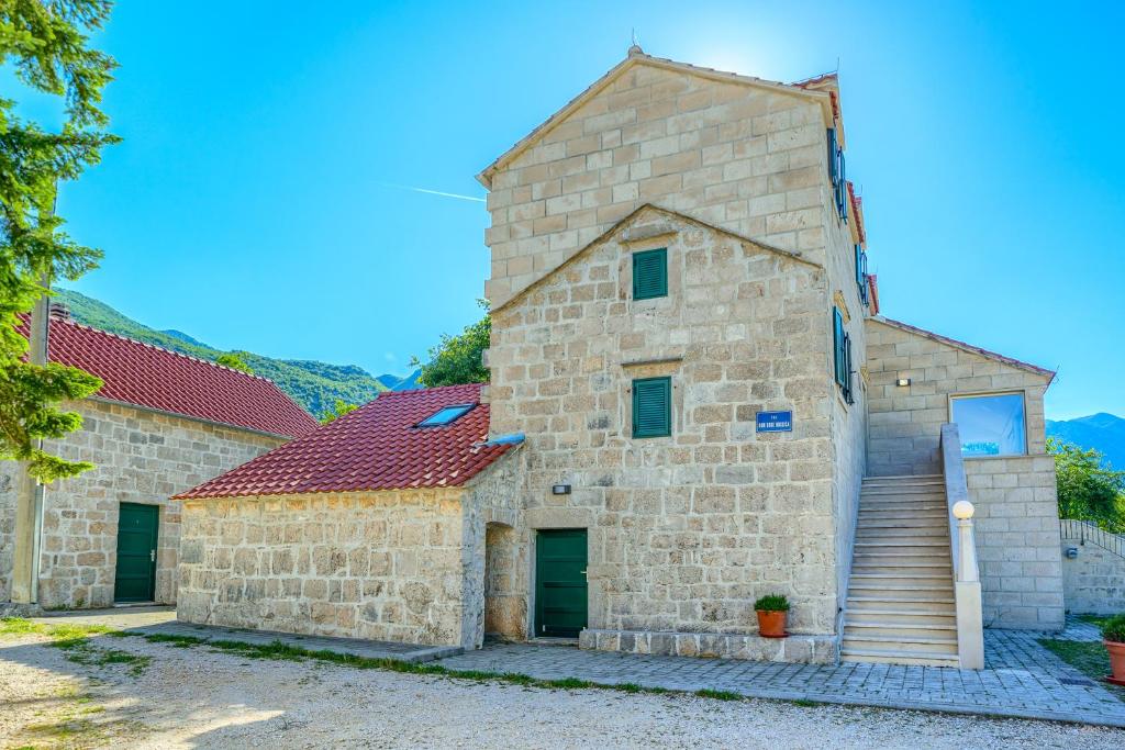 扎格沃兹德Your Ideal Haven for Serene Relaxation Villa Roglić near Baška Voda的一座红色屋顶的大型石头建筑