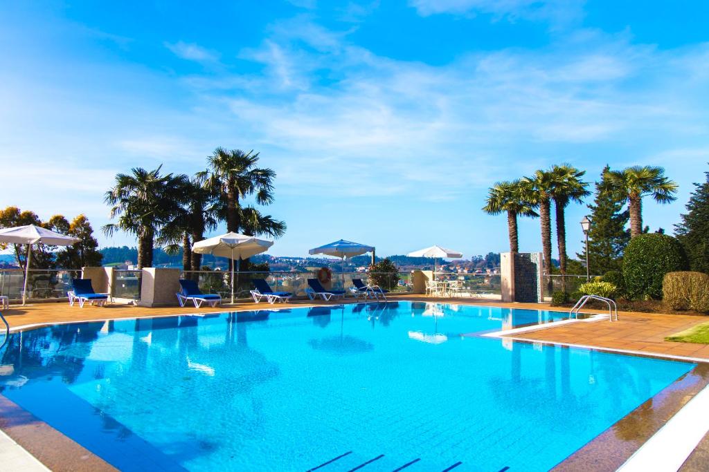 圣地亚哥－德孔波斯特拉洛萨贝托豪华酒店的一座种植了棕榈树的大型游泳池