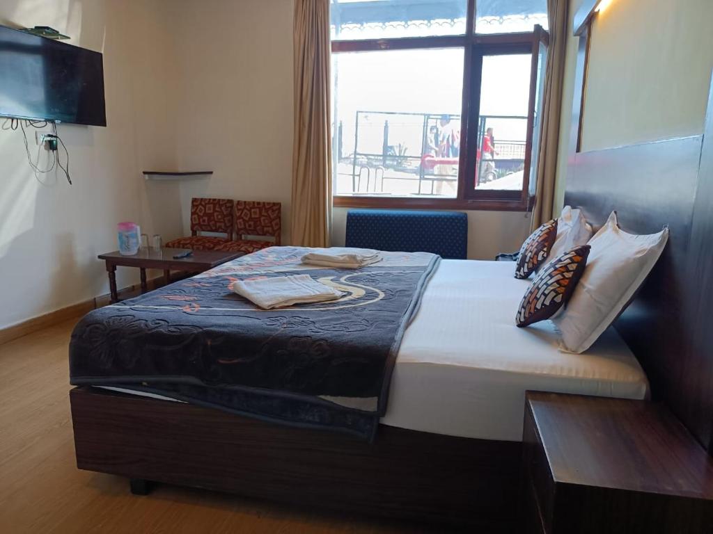 西姆拉zoz sm4的一间卧室配有一张带桌子和窗户的床