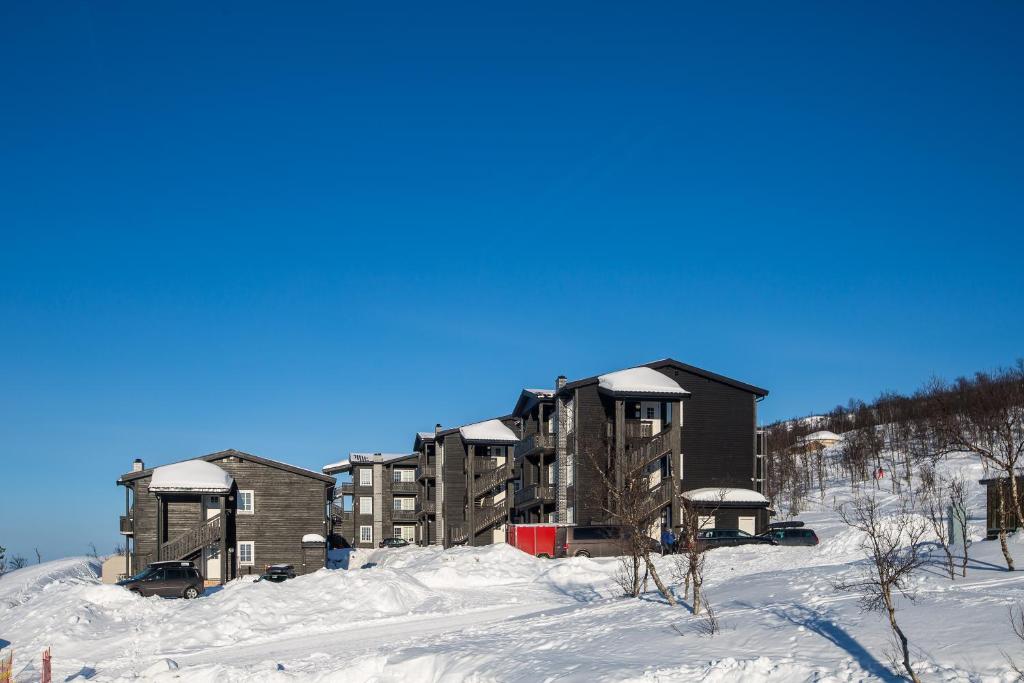 巴杜弗斯Målselv Fjellandsby Apartments的雪上积雪的建筑物