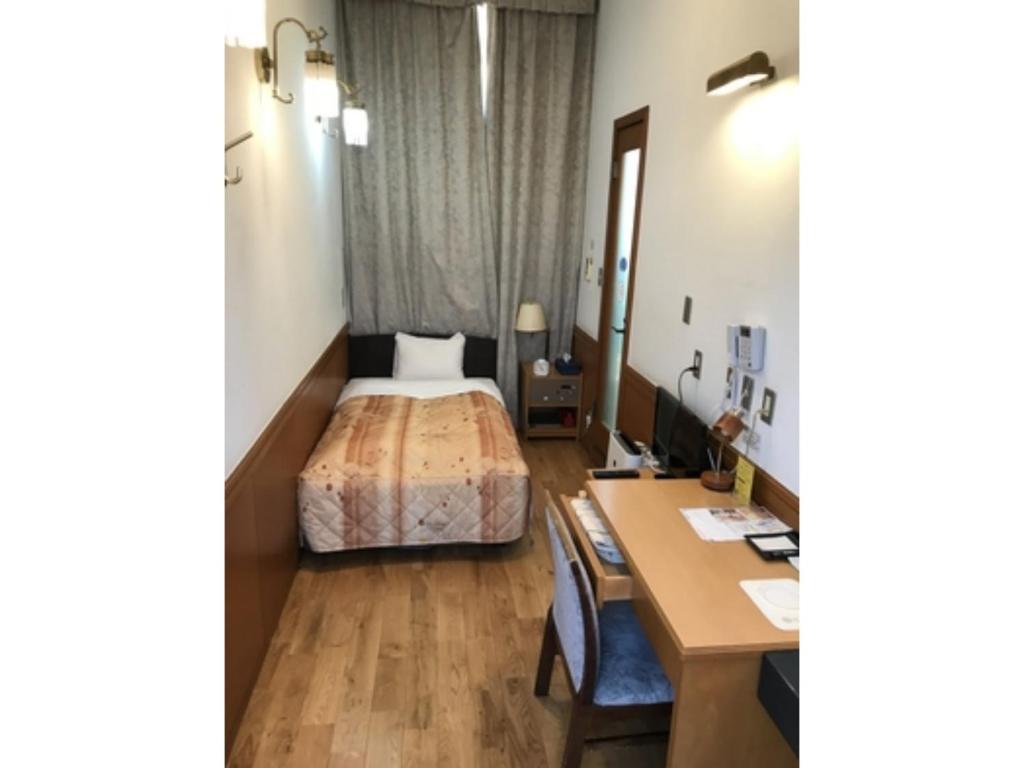 东京Business Hotel Crescent - Vacation STAY 49082v的配有一张床和一张书桌的酒店客房