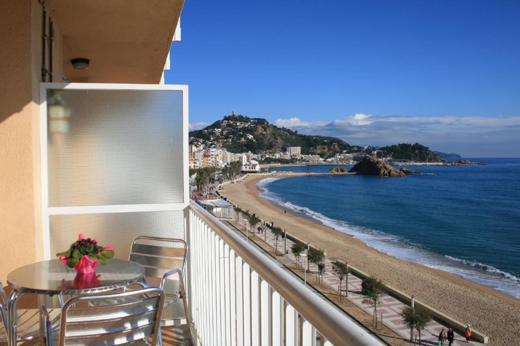 布拉内斯Apartaments El Sorrall的阳台配有桌子,享有海滩美景