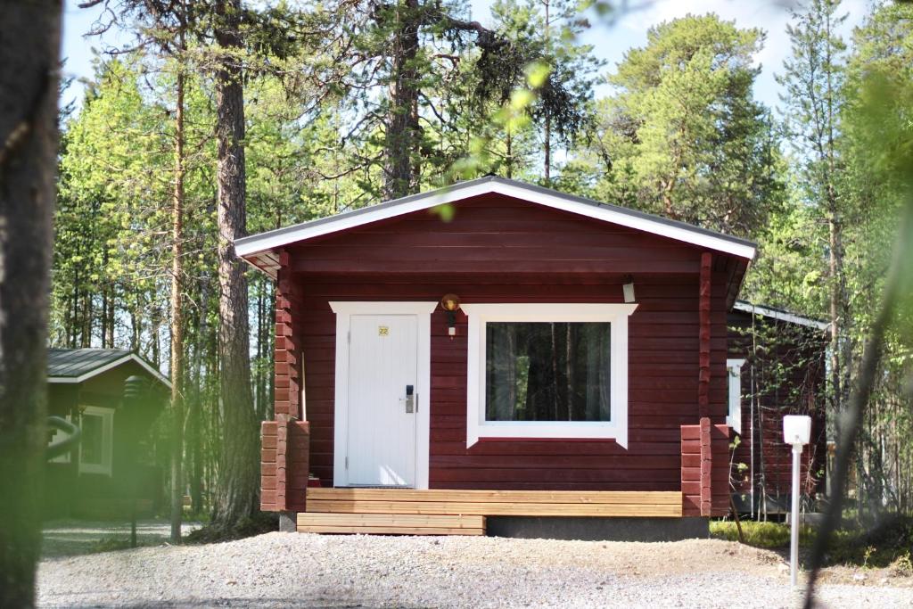 伊纳利Crow Creek Cabins的树林中带白色门的小小屋