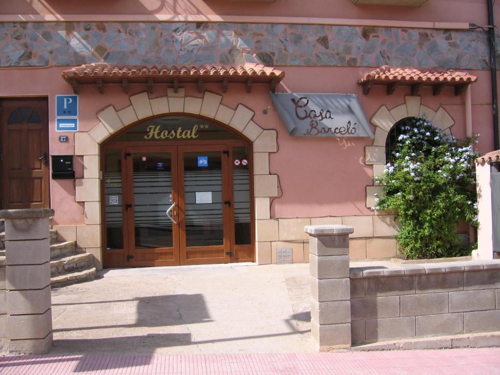 奥尔塔-德圣胡安巴塞罗旅馆的粉红色建筑前方的商店,设有木门