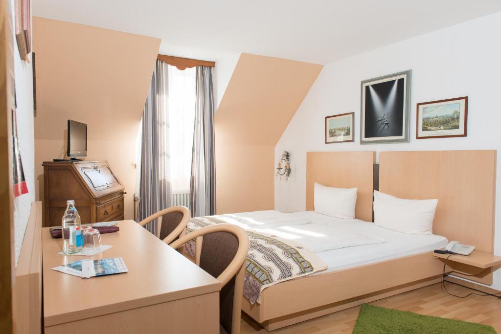 巴登-巴登弗里德里希酒店的酒店客房配有一张床铺和一张桌子。