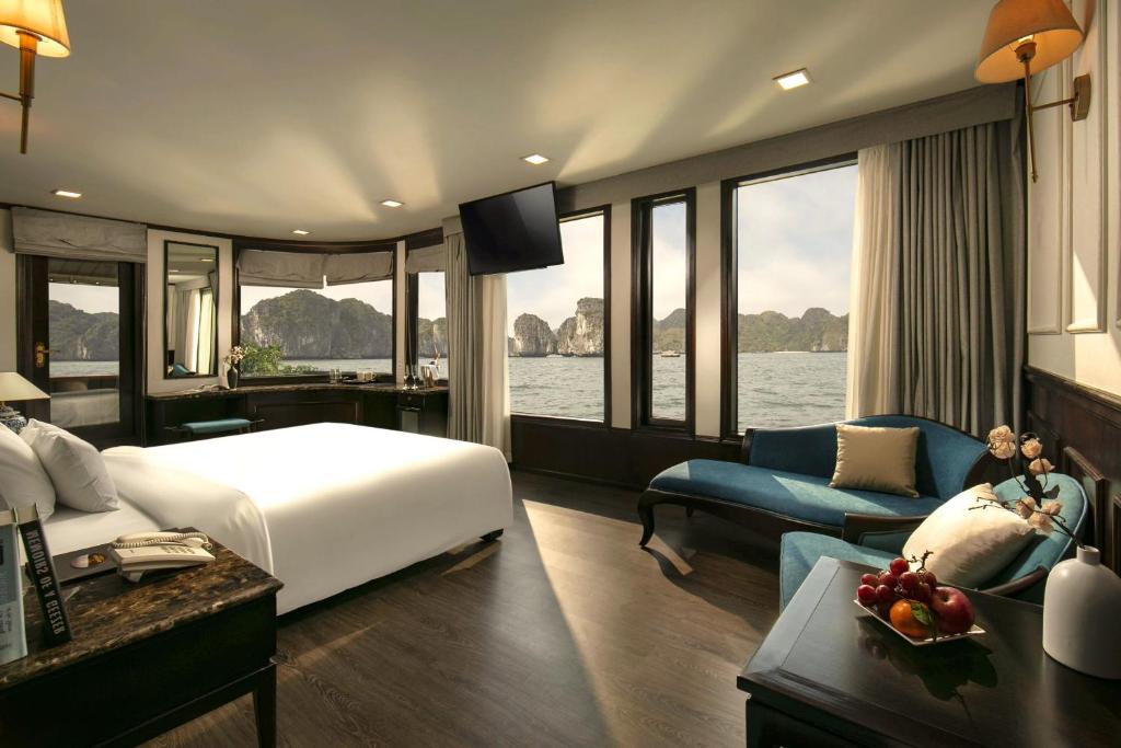 下龙湾Amanda Grand Lux Cruises Ha Long Bay的酒店客房设有一张大床和一张沙发。