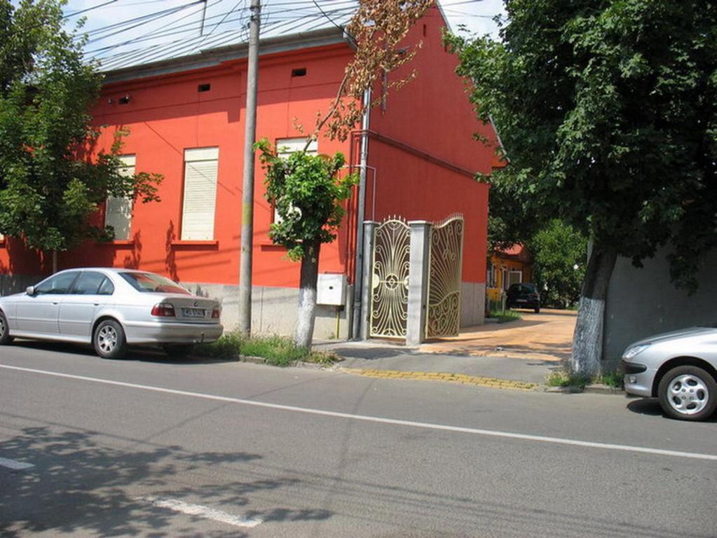 特尔古穆列什Noroc si Fericire的两辆汽车停在一座红色建筑前面