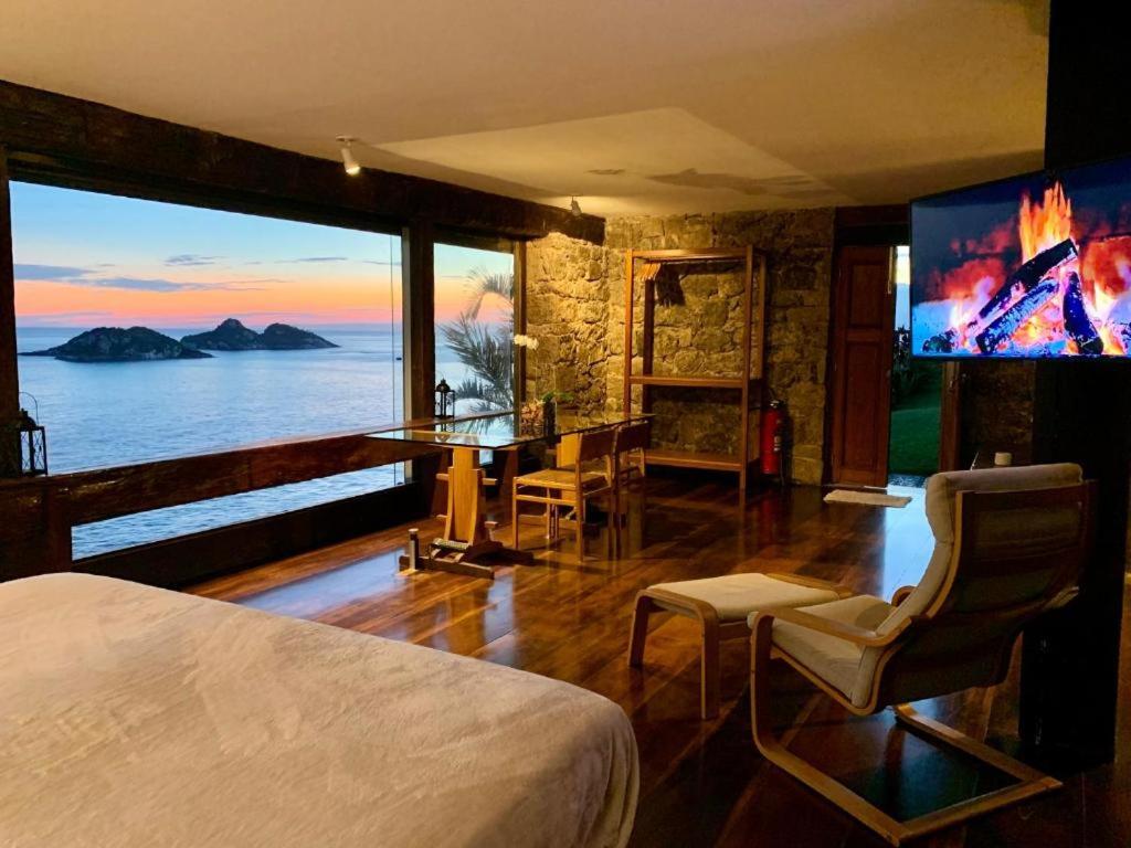 里约热内卢CLIFFSIDE - Boutique Hotel & Spa的一间卧室配有一张床、一张桌子和一个大窗户