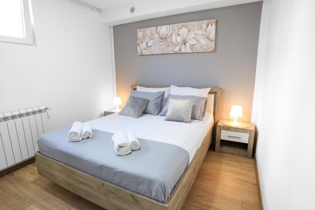 SurčinAirport Stay Apartments的一间卧室配有带毛巾的床