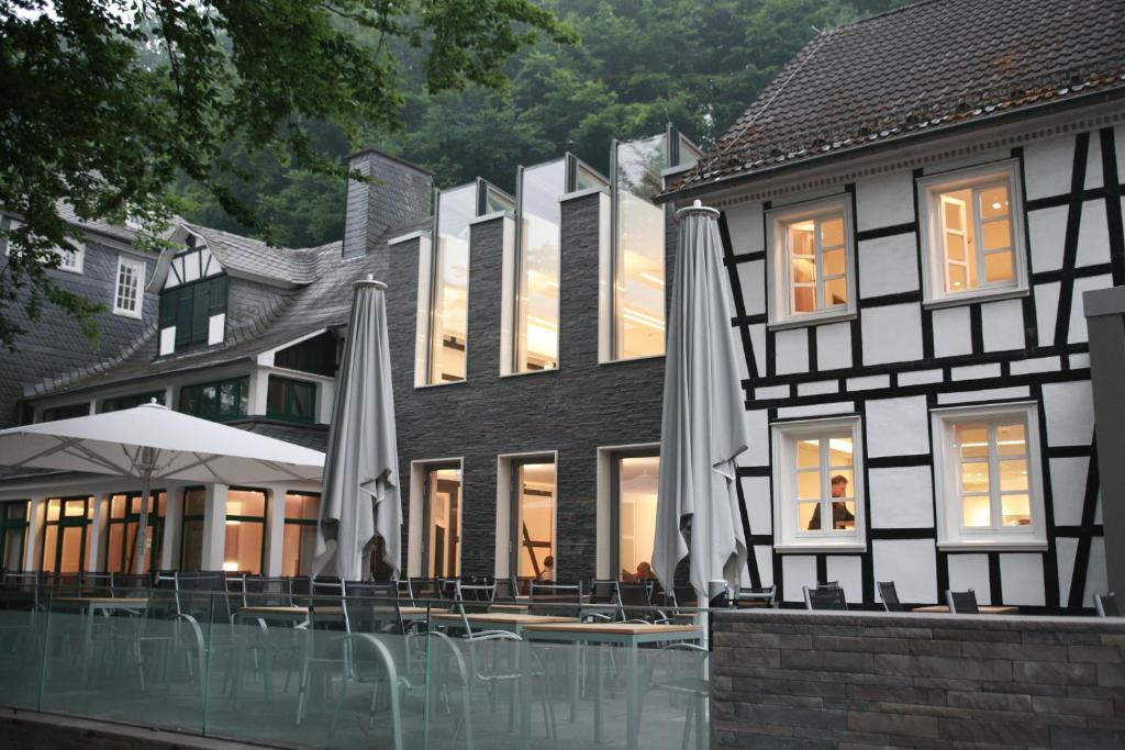 韦默尔斯基兴Seminar- & Tagungshotel Große Ledder的一座带户外露台的建筑,配有遮阳伞
