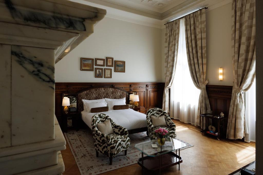 布鲁塞尔Hotel Fleur de Ville的一间卧室配有一张床、两把椅子和一张桌子