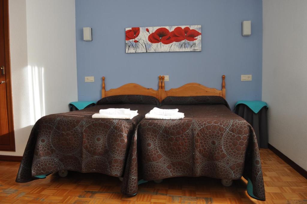 纳瓦莱诺Hostal La Tablada的一间卧室配有一张带两个枕头的床