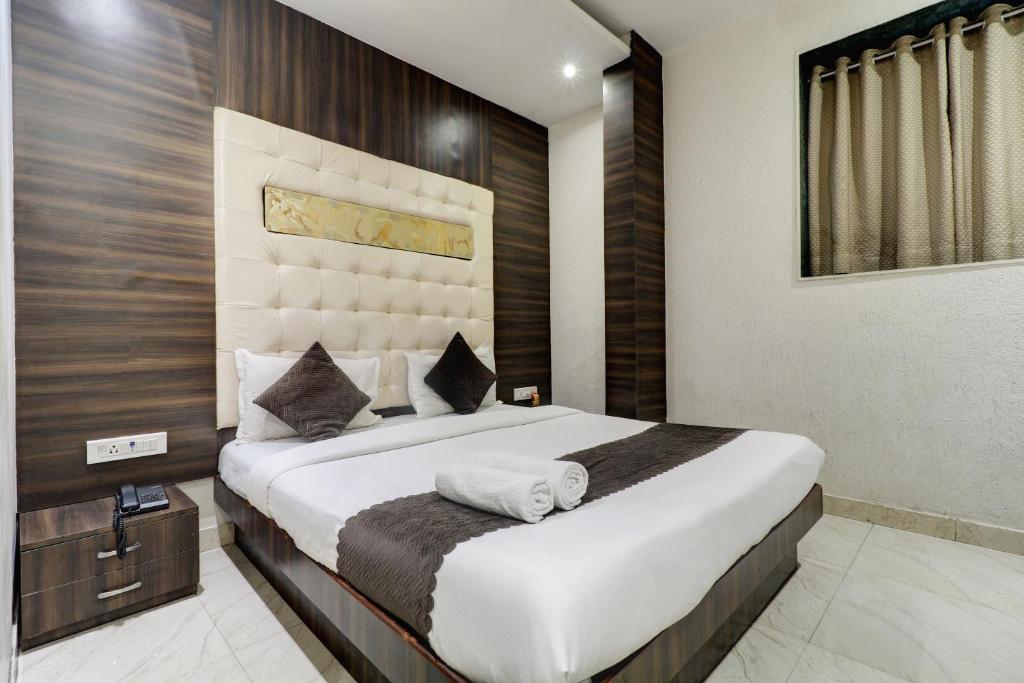 孟买Hotel A. K. International - Fort的一间卧室配有一张大床和毛巾