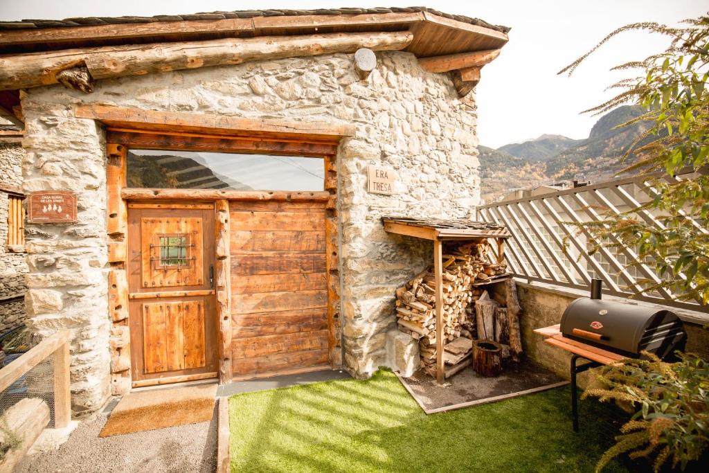 恩坎普R de Rural - Casa Rural de les Arnes的石头房子,带木门和烧烤架
