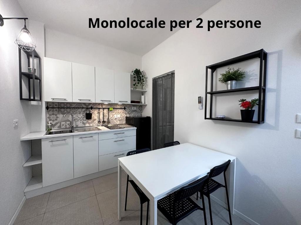 San Giorgio di PianoLa Casa di Leo Apartments的厨房配有白色橱柜和白色桌子