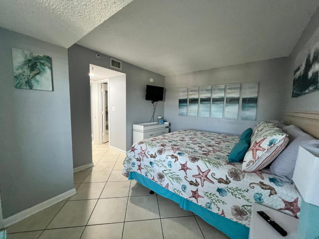默特尔比奇Oceanfront 2BR King Suite Atlantica Resort的一间卧室，配有一张床和瓷砖地板