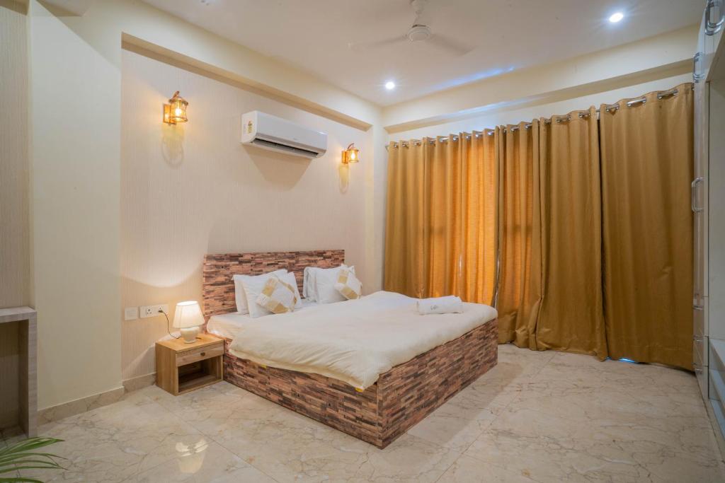古尔冈Hostie Eva Dreams - Private 2 BHK Apartments near Artemis, Medanta, Fortis hospitals的一间卧室设有一张大床和一个窗户。