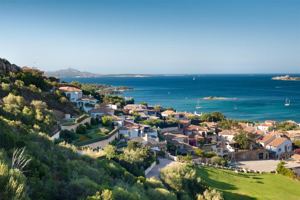 坎尼吉翁Aethos Sardinia的享有毗邻大海的山丘上村庄的空中景致