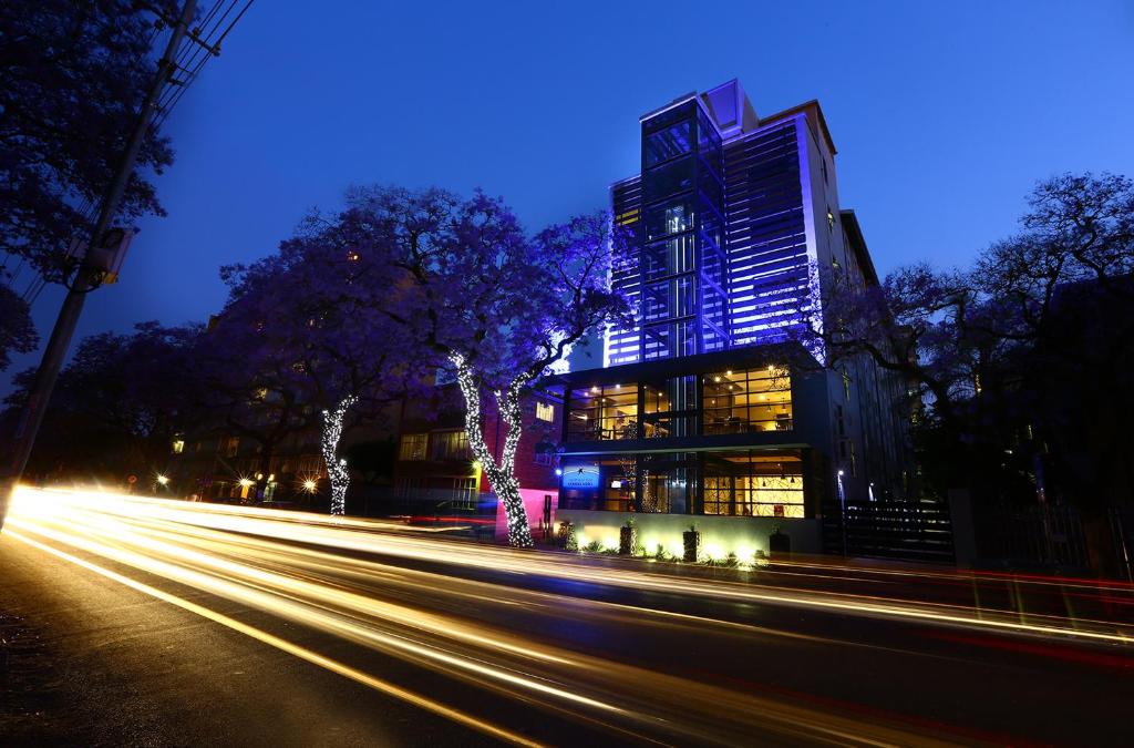 比勒陀利亚Inani Hotel Morning Star的一条城市街道,晚上有高大的建筑