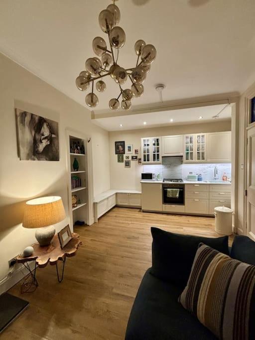 爱丁堡Welcoming Morningside Escape的客厅配有沙发和带台灯的桌子