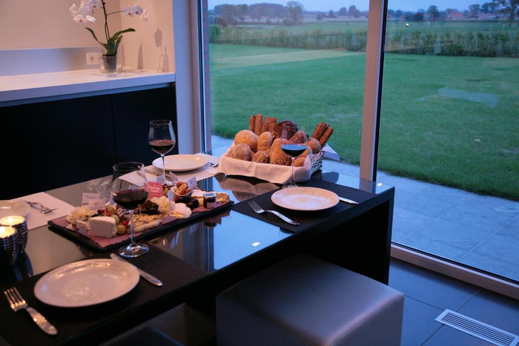 蒂尔特卡纳吉姆昂弗布鲁姆德膳宿酒店的一张桌子,上面放着一盘食物和一杯葡萄酒
