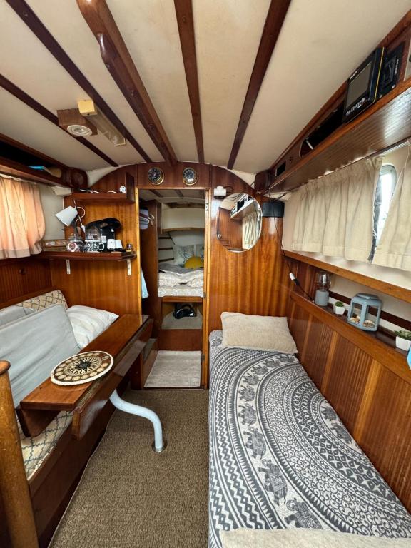 卡斯特尔德费尔斯Duerme acunado por el mar cerca de Barcelona的一间卧室配有一张床铺和一张桌子,位于货车内