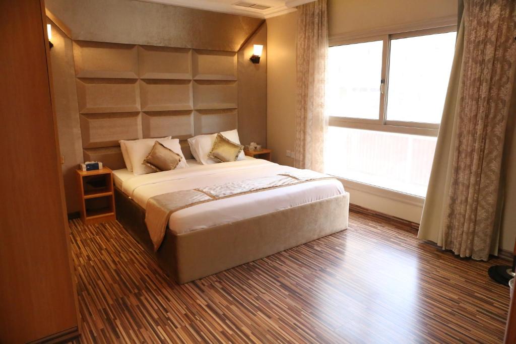 科威特Terrace Furnished Apartments - Mahboula的一间卧室设有一张大床和一个窗户。