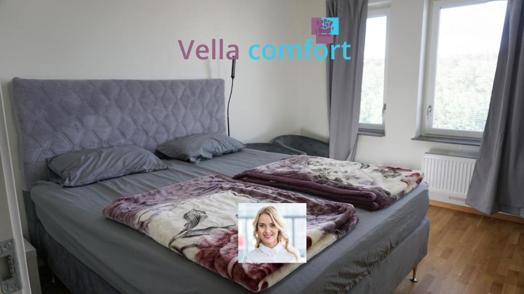 斯德哥尔摩Vella Comfort Stockholm的一张床上有一张女人的照片