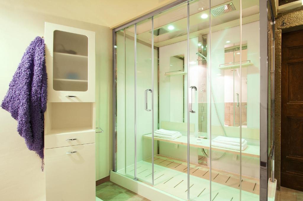 维泰博A Priori Guest House的浴室设有带电视的玻璃淋浴间